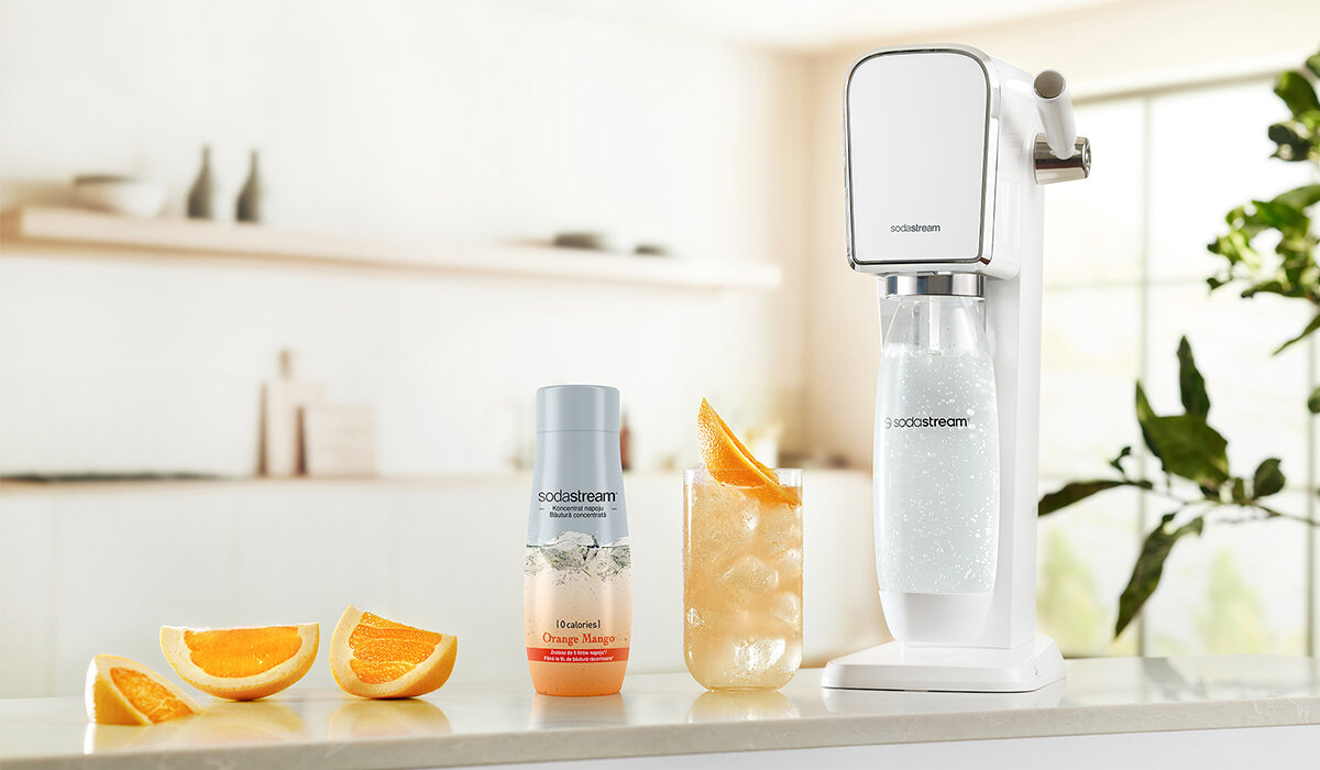 Syrop SodaStream Orange Mango Zero 440ml widok na butelkę syropu wraz z gotowym napojem oraz urządzeniem na tle kuchni 