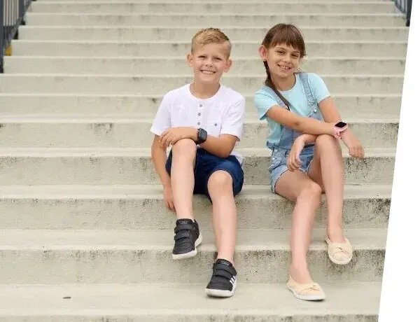 Smartwatch Garett Kids Sun Pro 4G widok na dwójkę dzieci z zegarkami założonymi na nadgarstkach