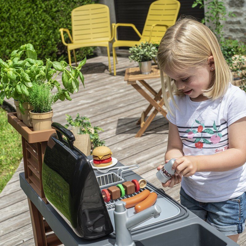 Kuchnia ogrodowa z regulacją wysokości Smoby 3+ dziewczynka bawiąca się kuchnią