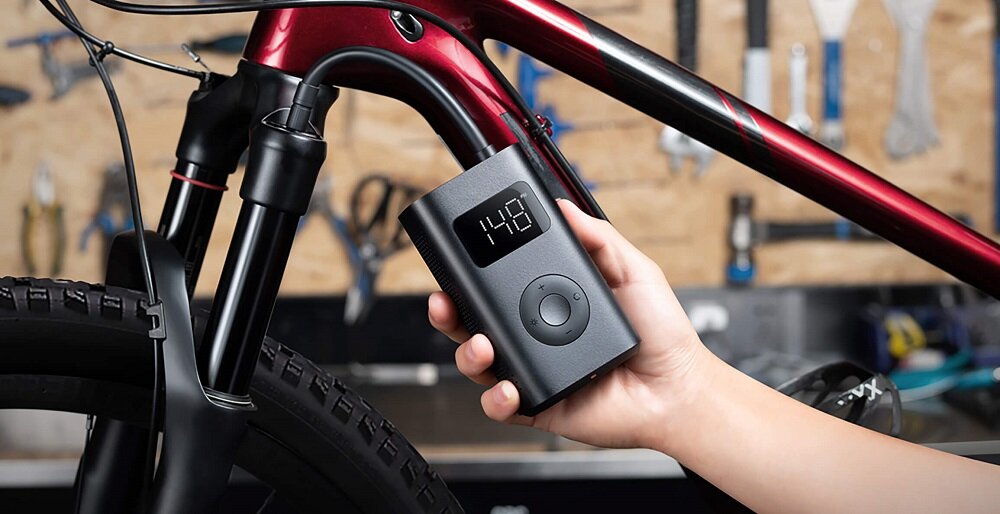 Pompka Xiaomi Mi Portable Electric Air Compressor 1S widok na pompkę pod skosem w lewo przy rowerze