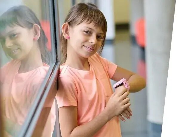 Smartwatch Garett Kids Twin 4G widok na dziewczynkę z różowym smartwatchem na nadgarstku