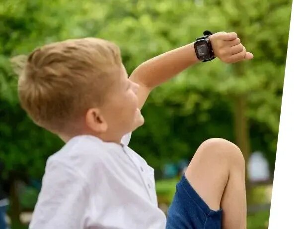 Smartwatch Garett Kids Cloud 4G widok na chłopca patrzącego na ekran smartwatcha