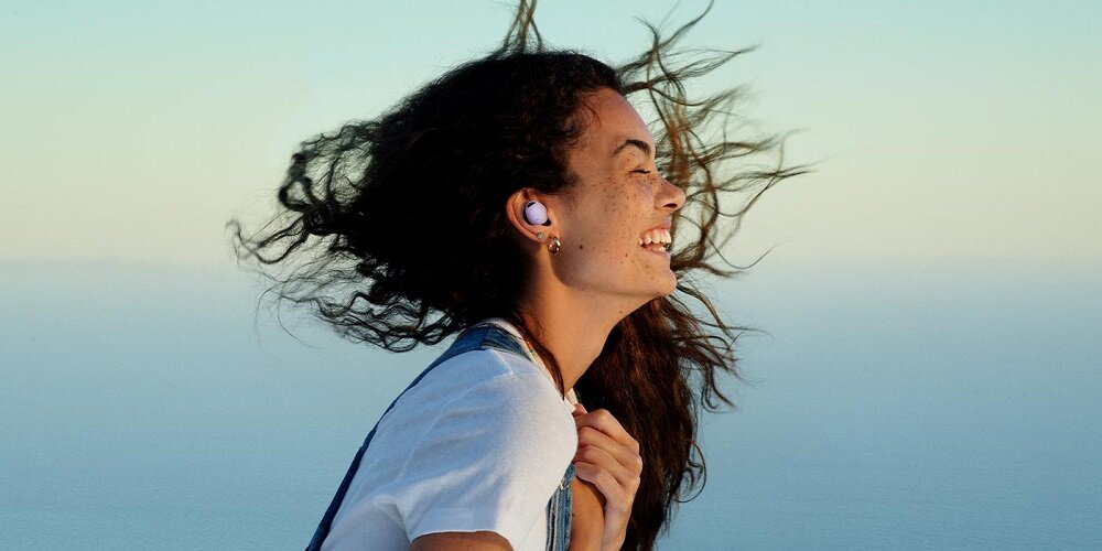 Słuchawki Samsung Galaxy Buds2 Pro SM-R510NLVAEUE widok na kobietę stojącą bokiem z widoczną słuchawką w uchu