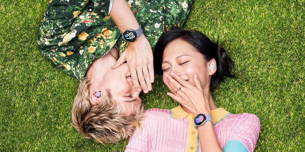 Smartwatch Samsung Galaxy Watch5 R905 SM-R905FZAAEUE widok na kobietę i mężczyznę leżących na trawie z zegarkami na nadgarstkach