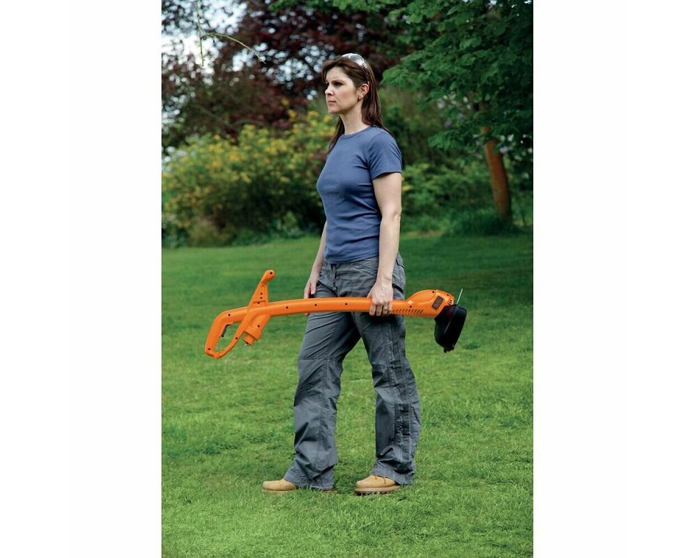 Podkaszarka do trawy Black&Decker GL360-QS widok na podkaszarkę od boku trzymaną przez kobietę w pozycji poziomej