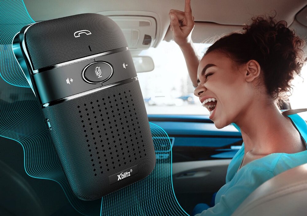 Zestaw głośnomówiący Xblitz X900 Pro widok na kobietę śpiewającą w samochodzie oraz na zestaw głośnomówiący pod skosem w lewo