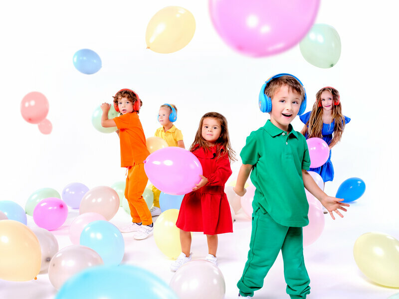 Słuchawki GoGEN DECKOSLECHYDUOB widok na grupę radosnych dzieci z kolorowymi balonami i słuchawkami na uszach