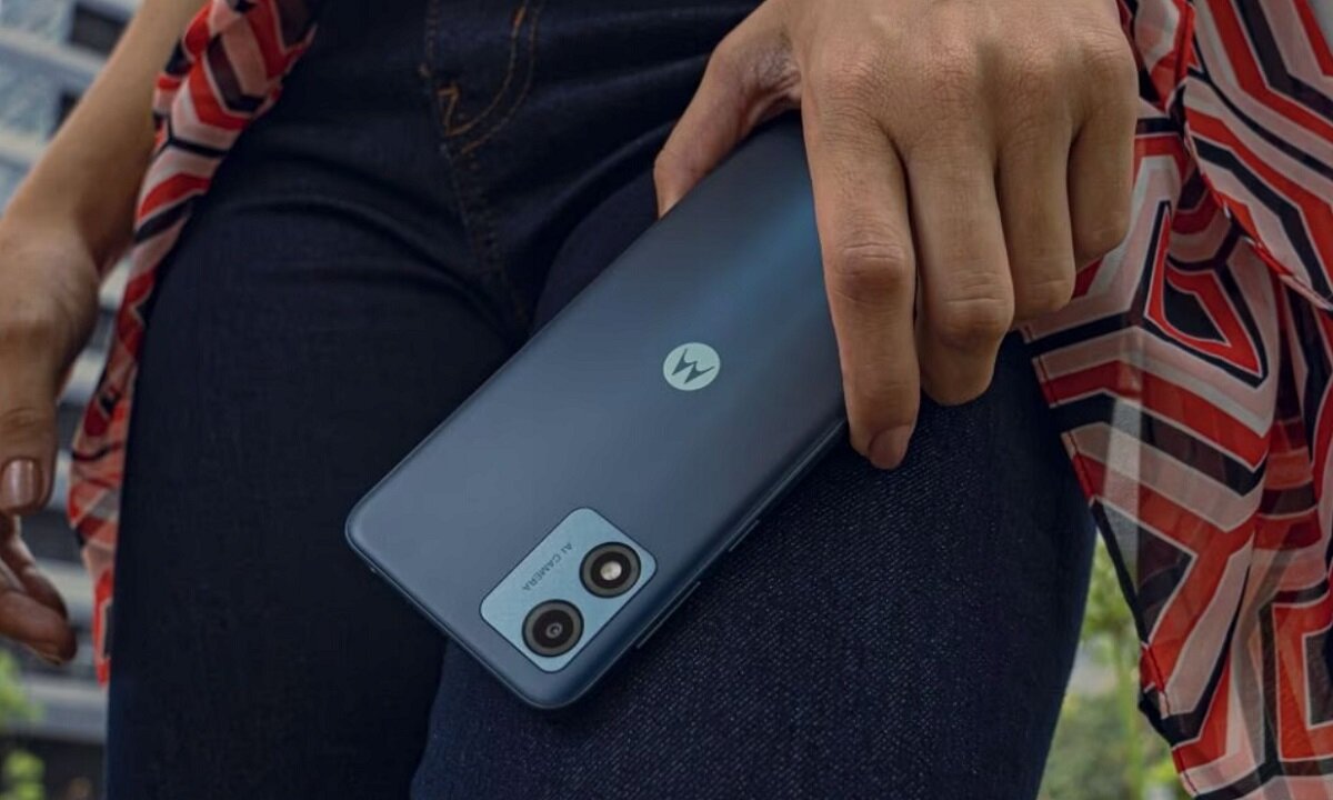 Smartfon Motorola Moto E13 2/64GB Czarny w ręce obok ud