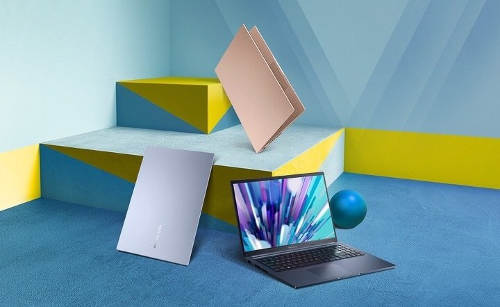 Laptop Asus Vivobook 15 D1502IA-BQ190W widok na szarego laptopa pod skosem w prawo oraz srebrnego i różowego laptopa pod skosem w lewo