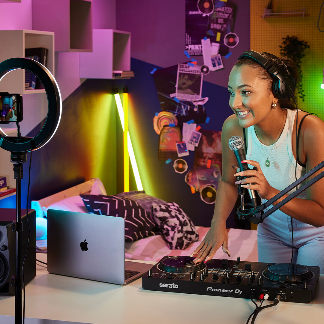 Kontroler Pioneer DDJ-REV1 kobieta z mikrofonem prowadząca stream muzyczny za pomocą kontrolera i laptopa