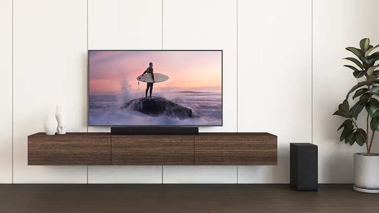 Soundbar LG S40Q od frontu podłączony pod telewizor z surferem na ekranie