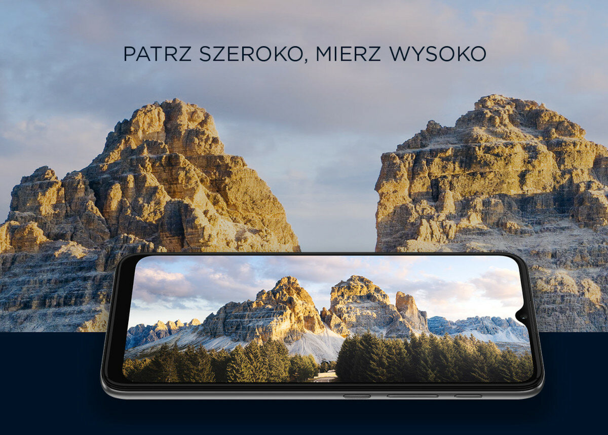 Smartfon Motorola moto e20 widok na zdjęcie gór wyświetlone na ekranie telefonu w pozycji poziomej oraz widok na góry w tle
