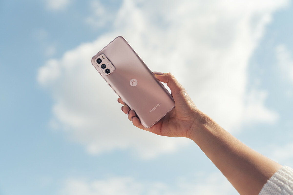 Smartfon Motorola moto g42 4/128GB różowy od tyłu, w dłoni kobiety na tle chmur