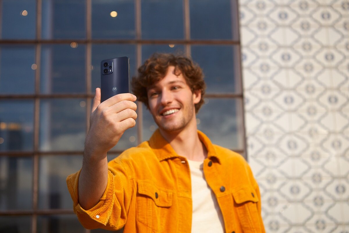 Smartfon Motorola moto g23 4/128GB grafitowy widok na telefon od tyłu trzymany w ręku przez mężczyznę