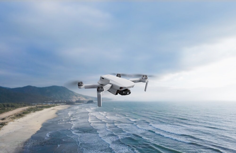 Dron DJI Mini 2 SE Single CP.MA.00000573.01 widok na drona lecącego nad pustą plażą