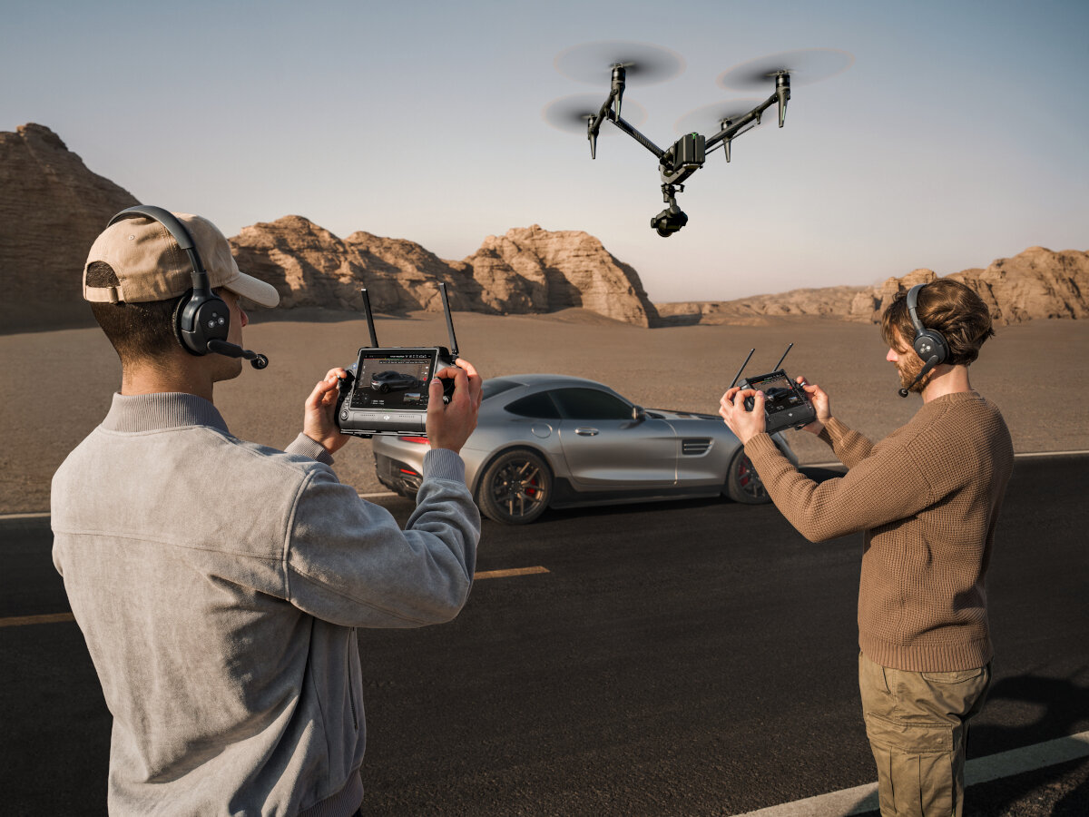 Dron DJI Inspire 3 94 km/h dwóch mężczyzn sterujących dronem, który unosi się w powietrzu