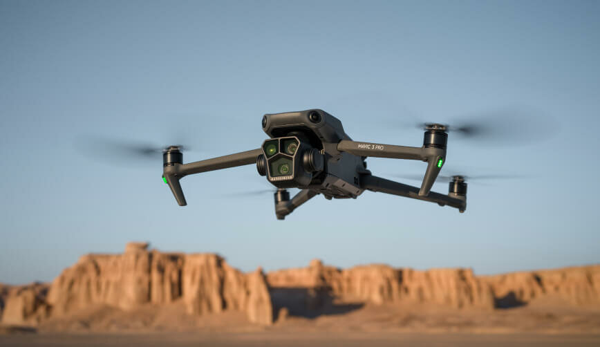 Dron DJI Mavic 3 Pro (DJI RC) 21 m/s pokazany dron unoszący się w powietrzu ukosem na tle gór