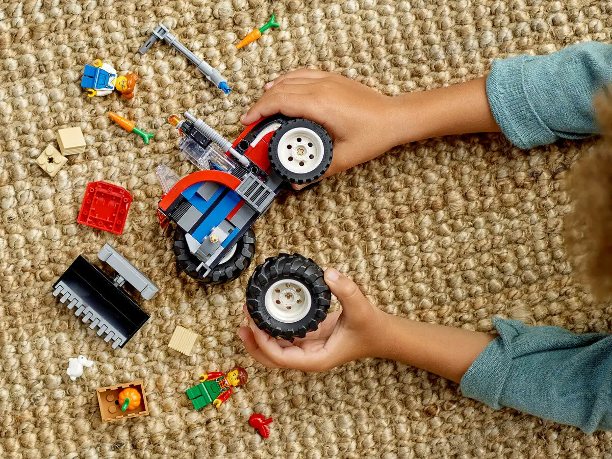 Klocki Lego City Traktor 60287 dziecko bawiące się traktorem na dywanie