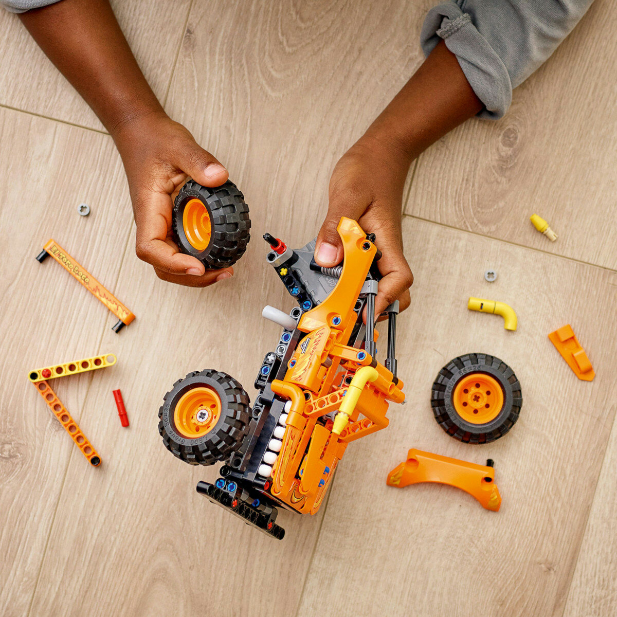 Klocki Lego Technic Monster Jam El Toro Loco 42135 widoczne dłonie chłopca, który składa pojazd z klocków