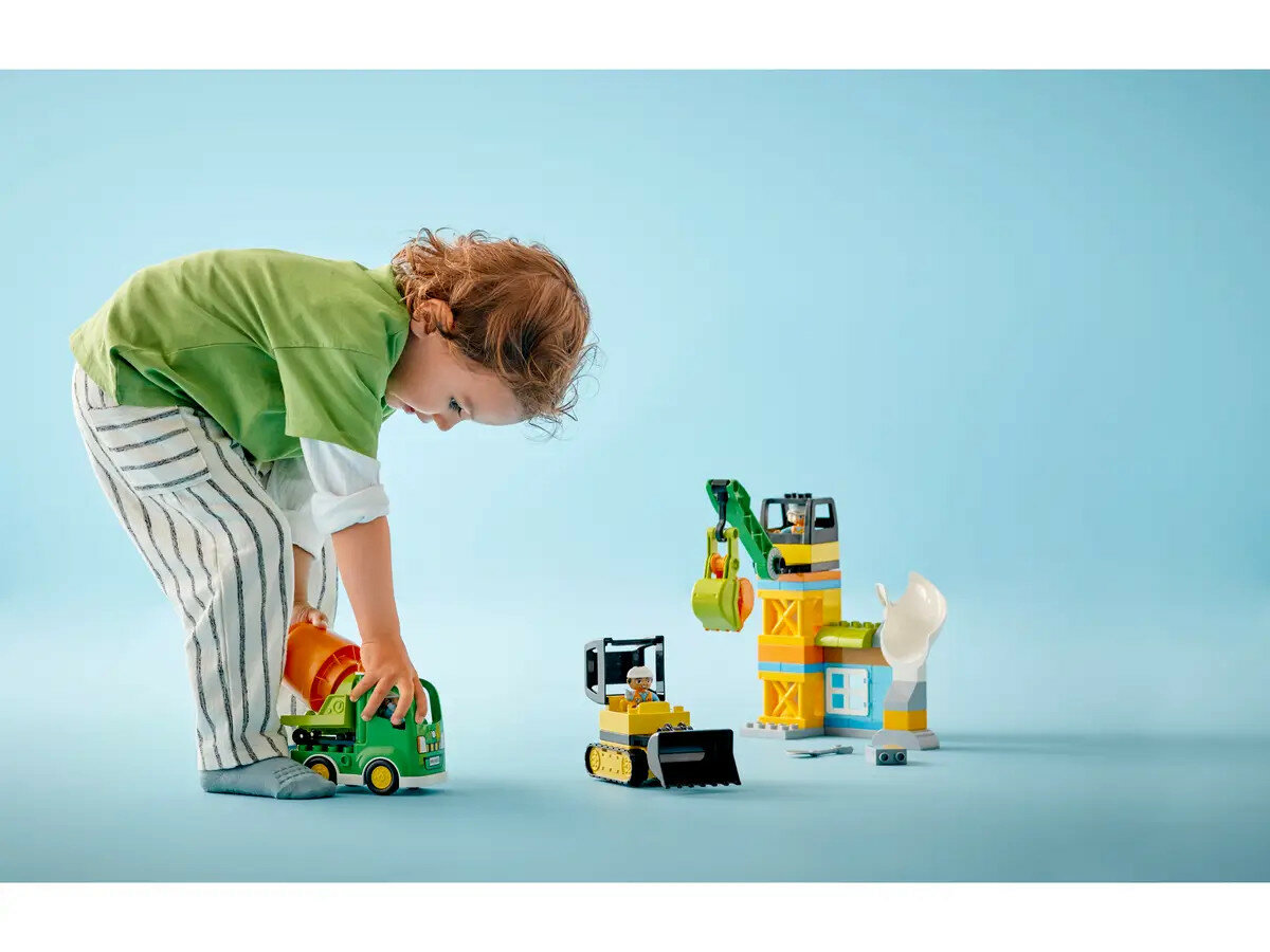 Klocki Lego Duplo Budowa 10990 dziecko bawiące się zestawem klocków w pozycji schylonej
