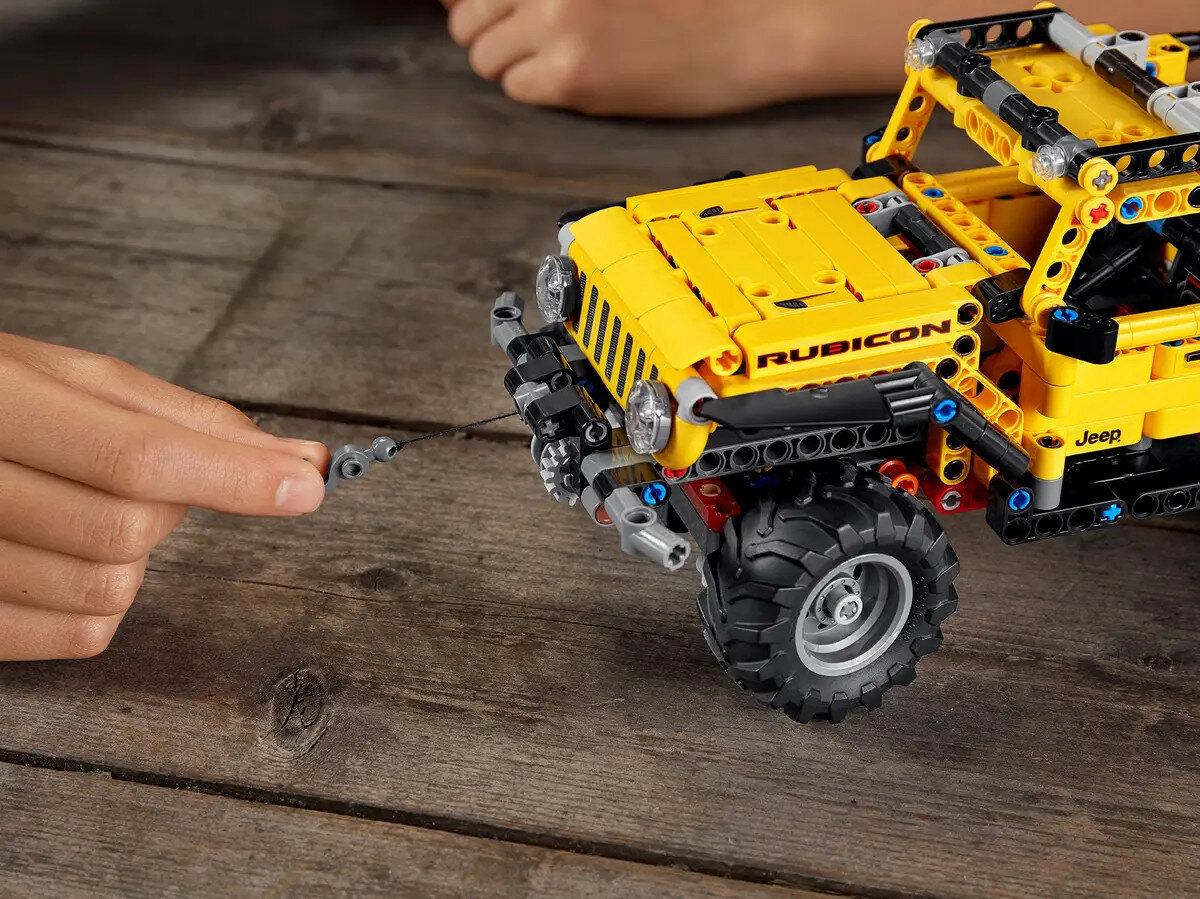 Klocki Lego Technic Jeep Wrangler 42122 widoczny pojazd od boku i dłoń dziecka