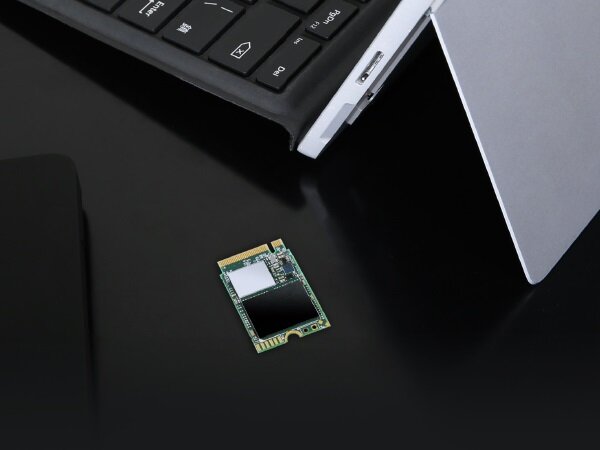 Dysk SSD Transcend MTE300S 512GB PCIe M.2 widok na dysk na czarnym tle obok laptopa