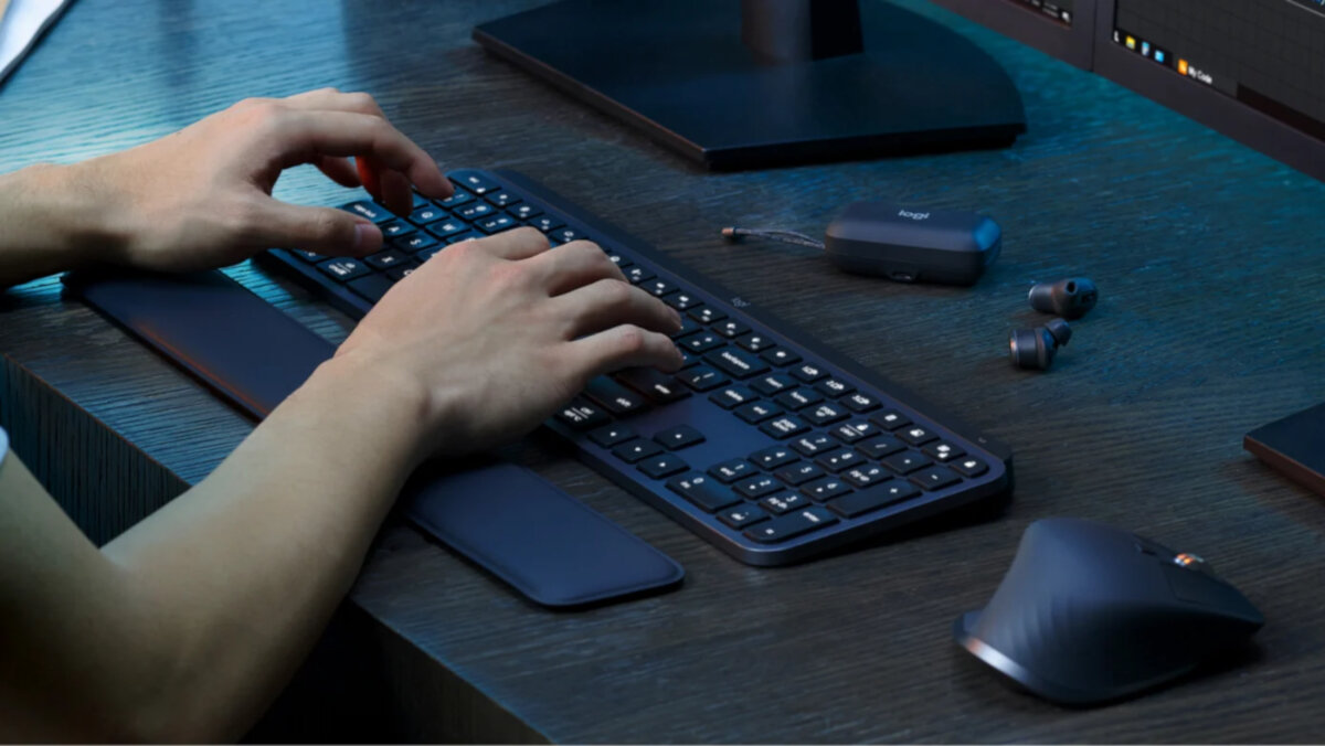 Zestaw klawiatura + mysz + podpórka pod nadgarstki Logitech MX Keys S grafitowy grafika przedstawia ręce na klawiaturze oparte na podpórce obok słuchawki i mysz