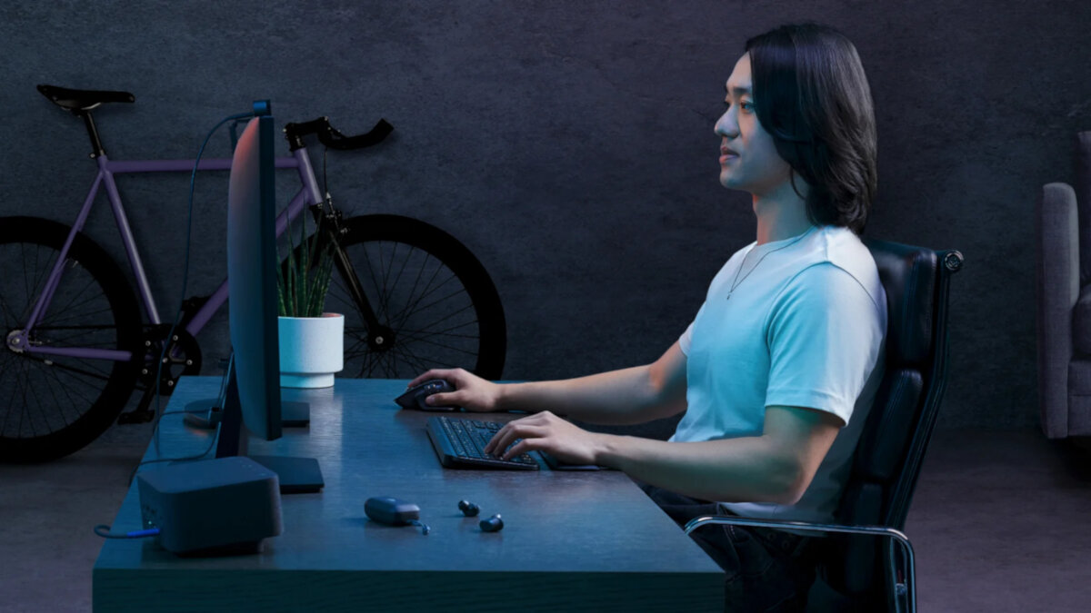 Zestaw klawiatura + mysz + podpórka pod nadgarstki Logitech MX Keys S grafitowy grafika przedstawia mężczyznę przed monitorem w tle rower