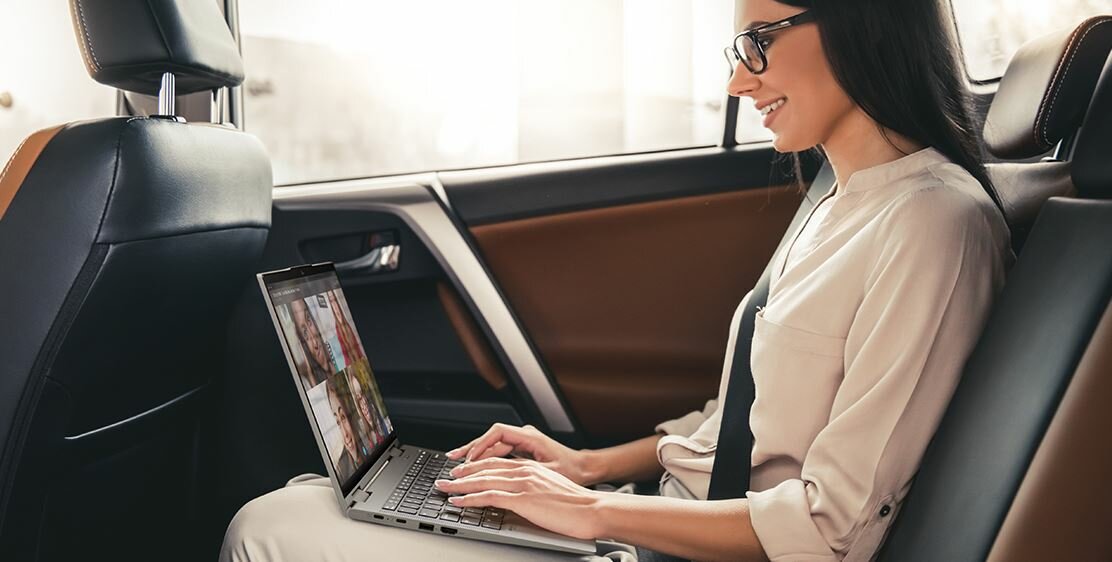 Laptop Lenovo ThinkPad X1 Yoga Gen 8 grafika przedstawia kobietę używającą laptopa w samochodzie