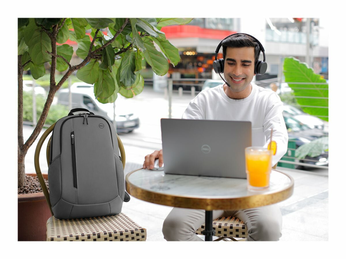 Plecak Dell Ecoloop Urban CP4523G szary męzczyzna pracujący na laptopie, z plecakiem obok