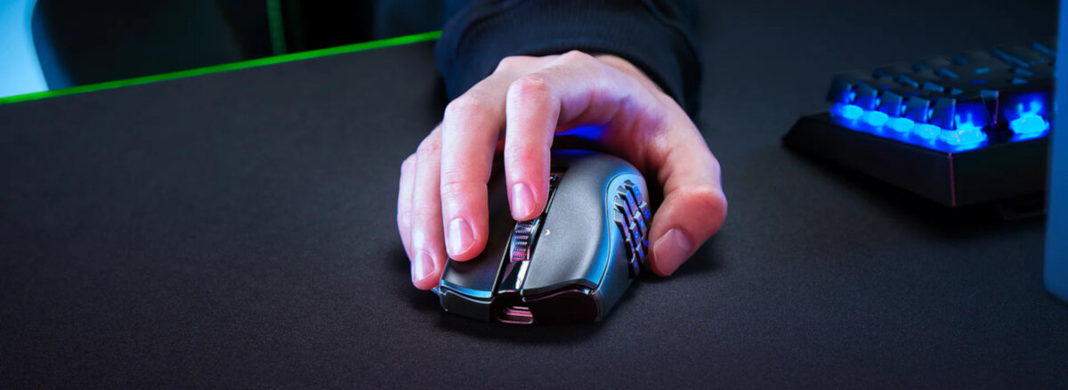 Mysz Razer Naga V2 Pro czarna, grafika przedstawia mysz w ręku, obok klawiatura podświetlona
