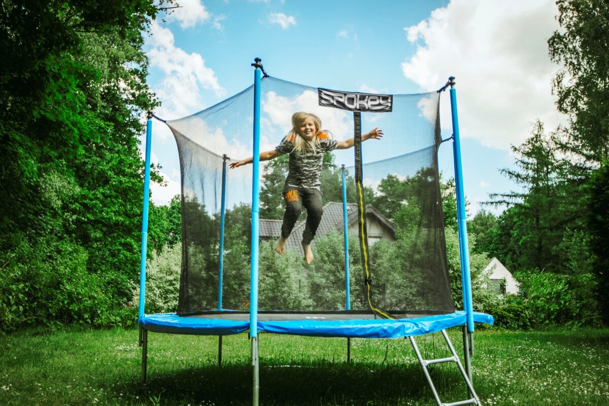 Trampolina ogrodowa Spokey Jumper II 305 cm grafika przedstawia dziecko skaczące na trampolinie