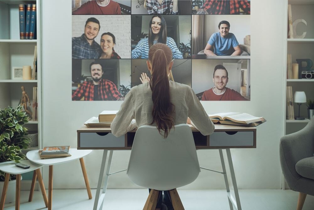 Projektor Optoma EH339 Full HD w pokoju używany do telekonferencji dla siedzącej kobiety