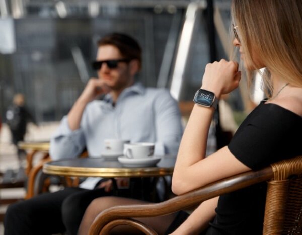 Smartwatch Garett GRC Style widok na parę przy stoliku przed kawiarnią
