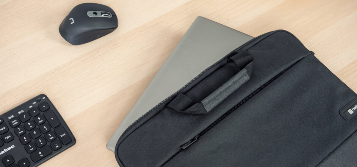 Torba na laptopa Natec Goa 15.6 czarna na biurku leży torba, w której znajduje się laptop, obok klawiatura i myszka