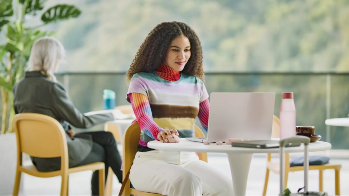 Mysz Logitech MX Anywhere 3S grafitowa grafika przedstawia kobietę siedzącą przed laptopem z ręką na myszce w tle kobieta siedząca przy stoliku