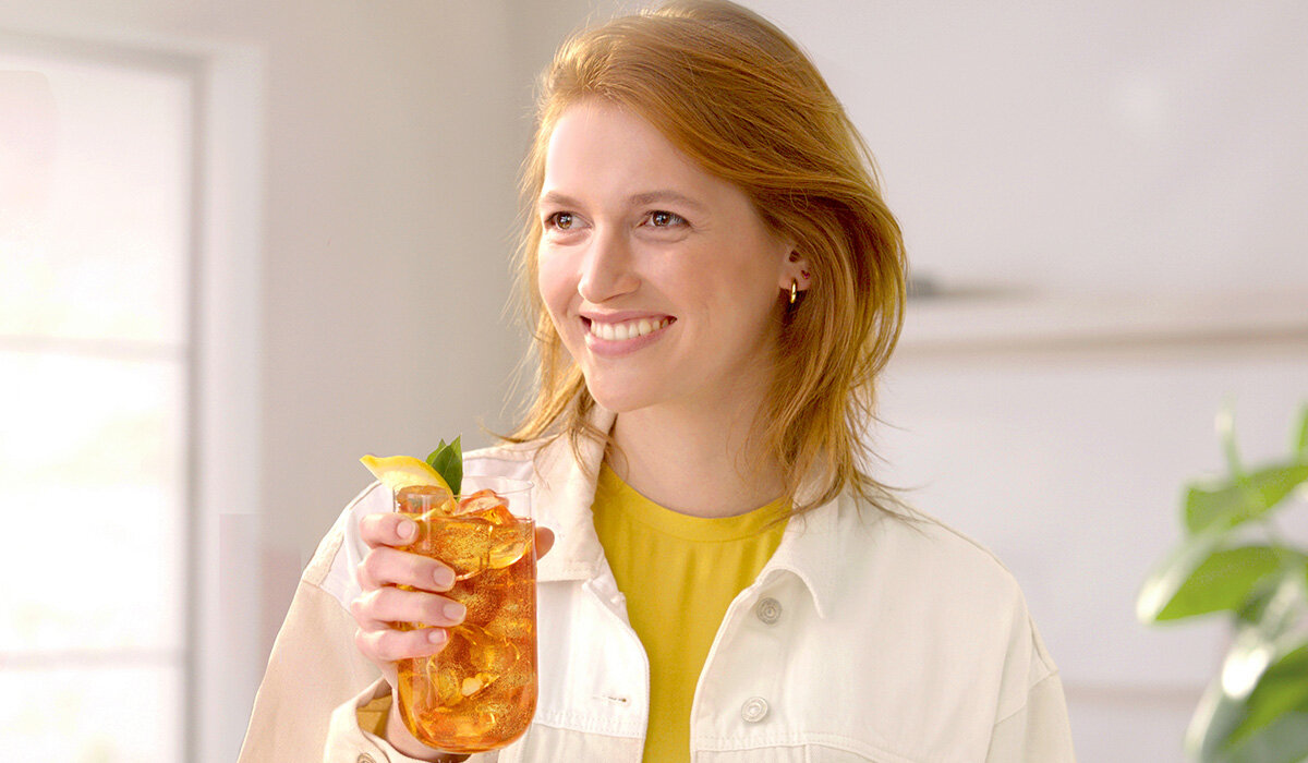 Syrop SodaStream Lipton Lemon Ice Tea widok na kobietę trzymającą gotowy napój w ręce