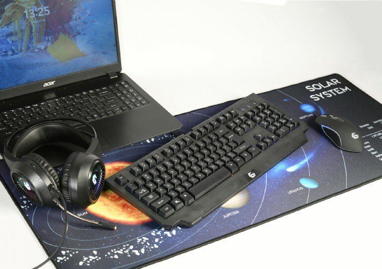 Podkładka pod mysz Gembird MP-Solarsystem-XL-01 układ słoneczny grafika przedstawiająca podkładkę na której leżą klawiatura, mysz, słuchawki oraz włączony laptop