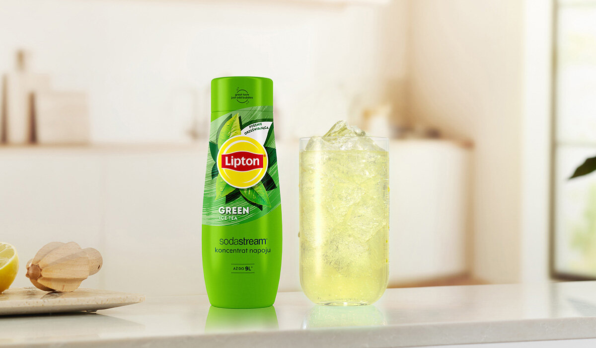 Syrop SodaStream Lipton Green Ice Tea butelka syropu wraz z gotowym napojem na tle kuchni