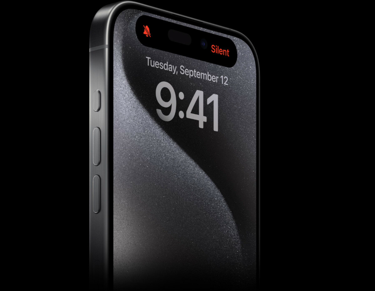 Smartfon Apple iPhone 15 Pro po skosie z widocznym powiadomieniem na ekranie