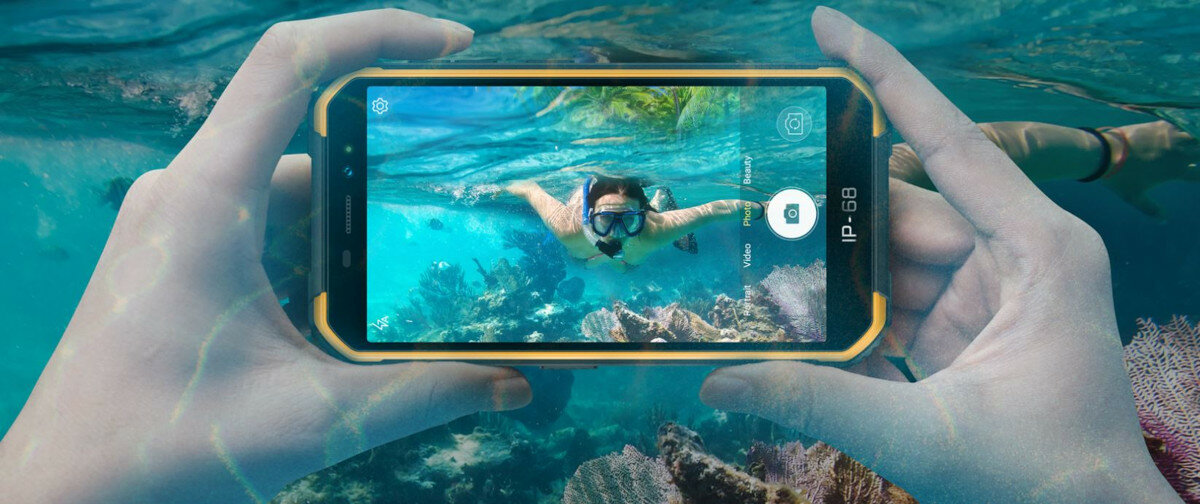 Smartfon Ulefone Armor X6 Pro 4/32GB czarny widok na smartfon trzymany w dłoniach w trakcie robienia zdjęcia pod wodą