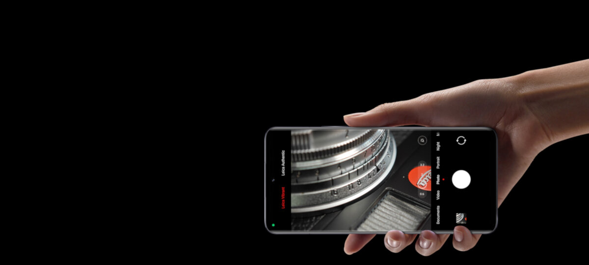 Smartfon Xiaomi 13 8/256 GB czarny grafika przedstawiająca rękę trzymająca smartfon od frontu z włączonym wyswietlaczem na czarnym tle