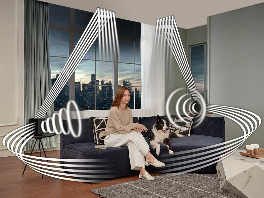 Soundbar Samsung HW-Q990C/EN czarny widok na kobietę z psem na kanapie słuchających dźwięków z soundbaru