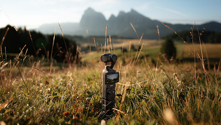 Kamera DJI Osmo Pocket 3 Creator Combo widok na kamerę w pozycji pionowej pod skosem na trawie
