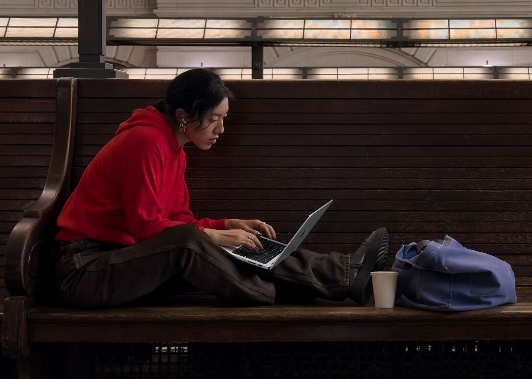 Laptop Apple Macbook Pro 14 M3 512 GB srebrny widok od boku na kobietę siedzącą na ławce z laptopem na kolanach