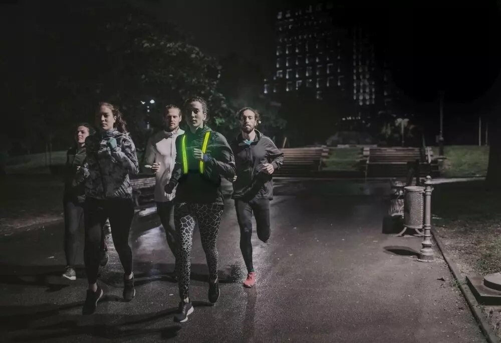 Kamizelka EasyPix StreetGlow L/XL grafika przedstawia grupę biegaczy w nocy w tym kobietę w kamizelce