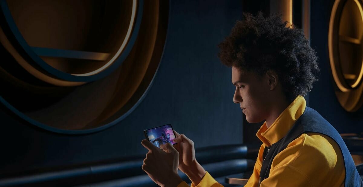Smartfon Xiaomi Poco X5 Pro 5G grafika przedstawia mężczyznę używającego smartfona