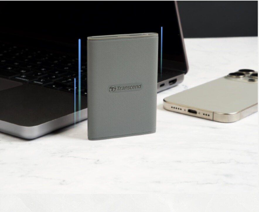 Dysk SSD Transcend ESD360C 4TB w pionie obok laptopa i smartfonu