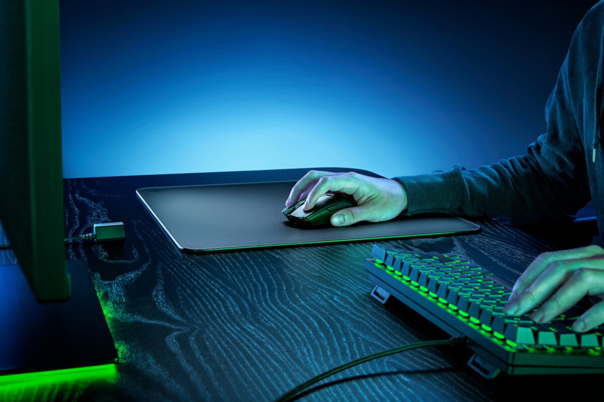 Podkładka pod mysz Razer Atlas czarna grafika przedstawia ręce mężczyzny na klawiaturze i myszce leżącej na podkładce przed nim monitor