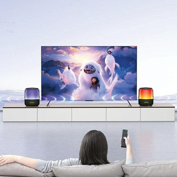 Głośnik Awei Y680 40W czarny widok na kobietę oglądającą film na telewizorze w salonie korzystając z dwóch głośników Awei